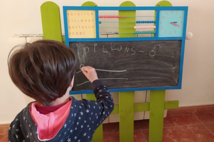 Nen escrivint en una pissarra d'escola | Imatge de l'Ajuntament de Palafrugell