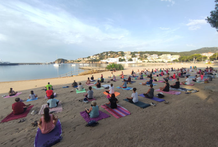 privat:-mes-d’un-centenar-de-persones-participen-en-el-primer-dia-de-les-classes-de-ioga-a-la-platja