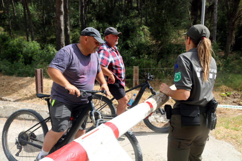 Un agent rural informant un grup de ciclistes que no es pot entrar al parc natural del Montgrí arran de l'elevat risc d'incendi i l'activació del nivell 3 del Pla Alfa Autor: Xavier Pi/ACN