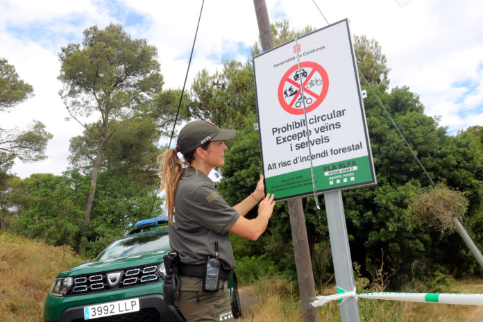 Una agent rural desplegant un cartell que informa sobre el tancament del parc natural del Montgrí a l'accés que dona a l'Estartit Data de publicació: dijous 07 de juliol del 2022, 12:54 Localització: L'Estartit Autor: Xavier Pi