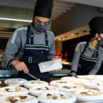 Dos cuiners preparant diferents plats al restaurant Bo.TiC de Corçà - Imatge de Gerard Escaich Folch