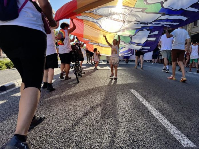 Child reaching for rainbow banner during 2023 Barcelona Pride Parade / Laura Busquets